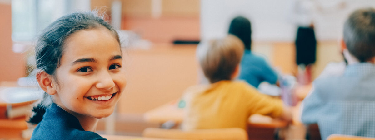 Smiling child at desk in classroom